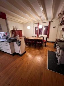 Villa du Cerney - Lac des Settons في Moux-en-Morvan: مطبخ وغرفة معيشة مع طاولة ومطبخ وغرفة طعام