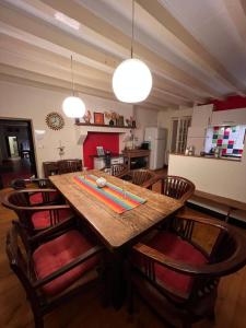 een keuken met een houten tafel en een aantal stoelen bij Villa du Cerney - Lac des Settons in Moux-en-Morvan