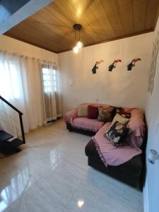 a living room with a couch and birds on the wall at Refúgio do Tucano in Alto Paraíso de Goiás