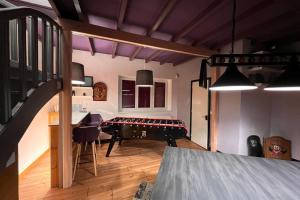 ein Wohnzimmer mit einem Tisch und einer Treppe in der Unterkunft Villa du Cerney - Lac des Settons in Moux-en-Morvan