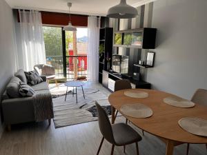 un soggiorno con divano, tavolo e sedie di El apartamento de Xavi ad A Coruña