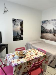 um quarto com uma mesa e uma cama e uma mesa e cadeiras em SWEET APT Piazza Statuto 9 Deluxe NEL PIENO CENTRO DI TORINO em Turim