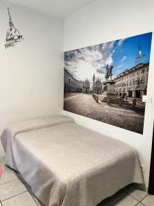 um quarto com uma cama com uma fotografia na parede em SWEET APT Piazza Statuto 9 Deluxe NEL PIENO CENTRO DI TORINO em Turim