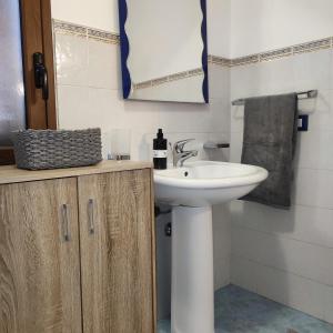 een badkamer met een wastafel en een witte wastafel bij La casa di Andrea in Terrasini