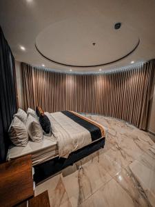 a bedroom with a bed in a room with a wall at منازل الطيف للشقق المخدومة in Buraydah