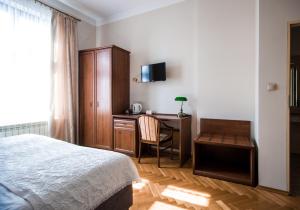 een slaapkamer met een bed, een bureau en een stoel bij Aparthotel Basztowa in Krakau