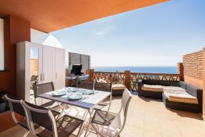 a balcony with a table and chairs and the ocean at Higuerón Rental Altos Duplex in Benalmádena