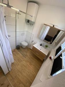 y baño con ducha, aseo y lavamanos. en Apartment MILENA Kaštela mit Whirlpool, en Kaštela