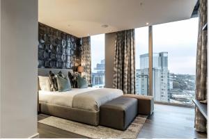 a bedroom with a large bed and a large window at The RoyalPlatinum Penthouse in Johannesburg