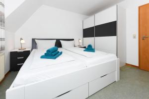 ein Schlafzimmer mit einem großen weißen Bett mit blauen Handtüchern darauf in der Unterkunft Ferienwohnung Deichblick in Bensersiel