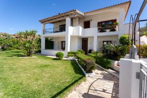 a villa with a lawn in front of it at Villetta Aurora in San Teodoro