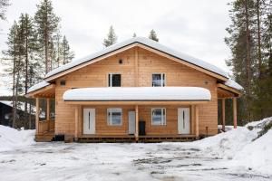 una casa de madera con nieve encima en Holiday in Lapland - Alatieva 3A en Kittilä