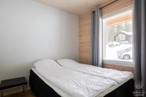 a bed in a room with a window at Holiday in Lapland - Alatieva 3A in Kittilä