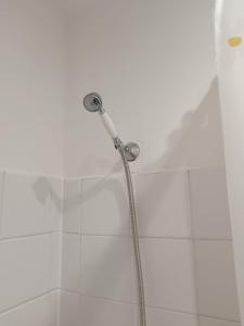 a shower head in a bathroom with white tiles at welcome to this flat in Kettering