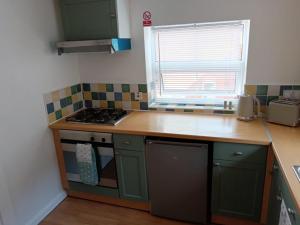 a kitchen with green cabinets and a counter top at welcome to this flat in Kettering