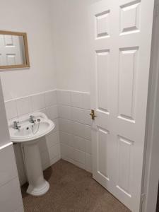 a bathroom with a sink and a white door at welcome to this flat in Kettering