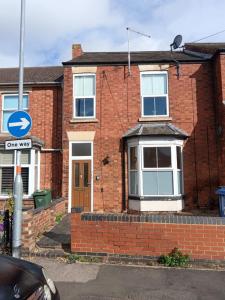 a brick house with a one way sign in front of it at welcome to this flat in Kettering