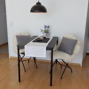a black and white table and a chair with a pillow at Seeblick in Daisendorf