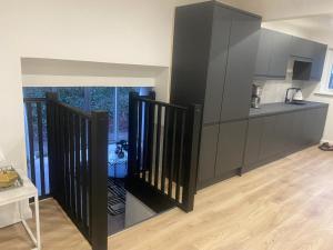 a kitchen with black cabinets and a kitchenette with a table at Beautiful 3-Bed House in Houston in Johnstone