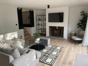 a living room with a couch and a fireplace at Sleeps7-Parking-Garden-Patio in Johnstone