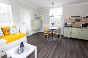 a room with a bed and a table and a kitchen at Ferienwohnung Alter Bahnhof in Kröslin