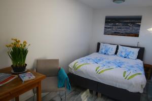a bedroom with a bed and a table and a desk at Studio Eb in Egmond aan Zee