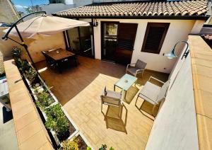 an overhead view of a patio with chairs and an umbrella at Holiday House Valpiè in Avola
