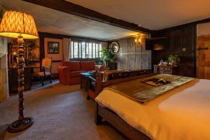 The George Inn & Plaine في Norton Saint Philip: غرفة نوم مع سرير وغرفة معيشة