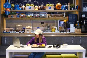 a woman sitting at a table with a laptop at Ibis Budget Bilbao City in Bilbao