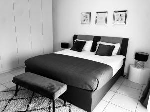 Habitación en blanco y negro con cama y taburete en LUXURY PENTHOUSE APARTMENT WITH 3 Balconies -2 BEDROOMS & PETRUS VIEW en Luxemburgo