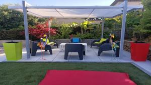 un patio avec des chaises et des tables ainsi qu'un auvent blanc dans l'établissement Villa Andalucia, Piscine Chauffée, à La Ciotat