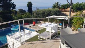 balkon z białymi krzesłami i basenem w obiekcie Villa Andalucia, Piscine Chauffée w mieście La Ciotat