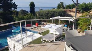 a balcony with white chairs and a swimming pool at Villa Andalucia, Piscine Chauffée in La Ciotat