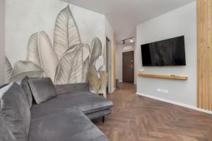 a living room with a couch and a flat screen tv at 5 minut do Plaży - Apartament MORZETU z Tarasem by Renters in Gąski
