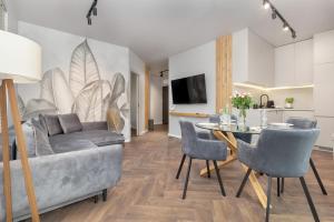 uma sala de estar com um sofá e uma mesa em 5 minut do Plaży - Apartament MORZETU z Tarasem by Renters em Gąski
