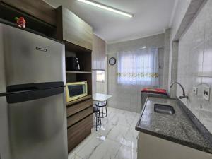 a kitchen with a stainless steel refrigerator and a sink at 095 Tupi Vista Mar I - Tupi - 30 metros da praia - 1 dormitório com VARANDA - Wi fi e acomoda até 5 pessoas - Estacionamento Gratuito ap.95 in Praia Grande