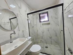 a bathroom with a shower and a toilet and a sink at 095 Tupi Vista Mar I - Tupi - 30 metros da praia - 1 dormitório com VARANDA - Wi fi e acomoda até 5 pessoas - Estacionamento Gratuito ap.95 in Praia Grande