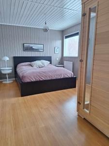 een slaapkamer met een bed en een houten vloer bij Dimond cottage in Laxamýri