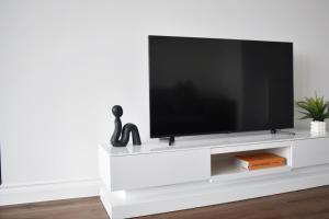 a white tv stand with a flat screen tv at Amazing 2BR in Brentwood in Brentwood