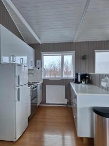 cocina con electrodomésticos blancos y suelo de madera en Dimond cottage en Laxamýri