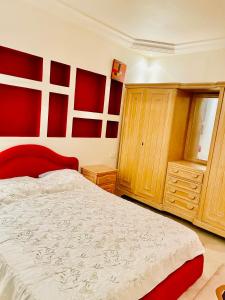 een slaapkamer met een groot bed en houten kasten bij 40€/j شقة غرفة نوم 1 في فيلا حي النصر in Ariana