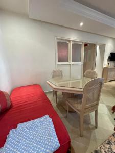 een woonkamer met een tafel en een rode bank bij 40€/j شقة غرفة نوم 1 في فيلا حي النصر in Ariana