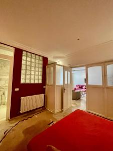 een woonkamer met rode muren en een rood tapijt bij 40€/j شقة غرفة نوم 1 في فيلا حي النصر in Ariana