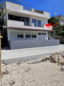 a building with a red arrow in front of it at Apartment Hajdi in Podstrana