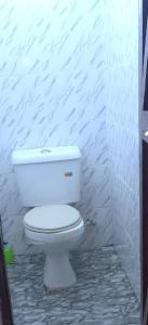 a bathroom with a white toilet in a room at Maridadi place in Kakamega