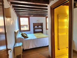 Lo Squero apt في البندقية: غرفة نوم صغيرة بها سرير ونافذة
