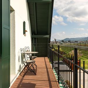 einen Balkon mit einem Stuhl, einem Tisch und Aussicht in der Unterkunft Bed & Breakfast Dvorec in Petrovče