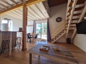 uma sala de estar com uma mesa e uma escada em Paisible maison à l'ombre des pins em Fitou