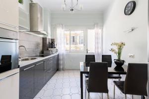 ニースにあるNOTRE DAME - Huge sunny modern 2BR flat - Terraceの白いキッチン(ダイニングテーブル、椅子付)