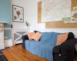 uma sala de estar com um sofá azul com almofadas em Arlington Villas Townhouse by Clifton Short Lets em Bristol